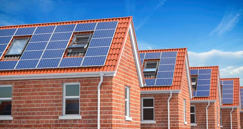 Row of house with solar panels on roof on blue sky AZR29 CK